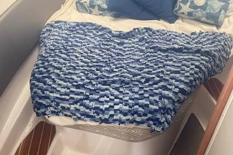  Yacht Photos Pics 2020 Cutwater C-32 C cabin interior with blue patterned blanket and pillows.