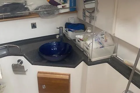  Yacht Photos Pics 2020 Cutwater C-32 C bathroom with blue sink and storage shelves.