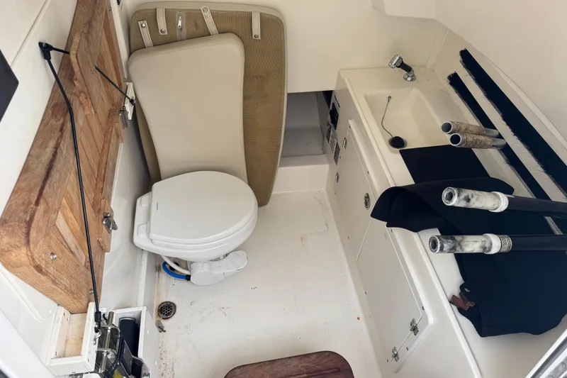  Yacht Photos Pics 2019 Boston Whaler 330 Outrage cabin with toilet, sink, and storage area.