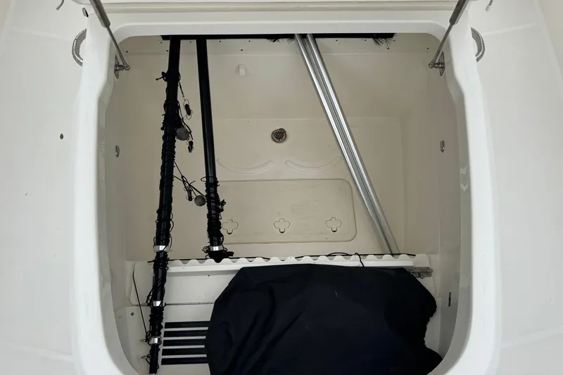  Yacht Photos Pics Storage compartment of a 2019 Boston Whaler 330 Outrage boat, featuring fishing gear.