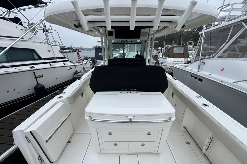  Yacht Photos Pics 2019 Boston Whaler 330 Outrage boat interior at marina, featuring seating and storage.