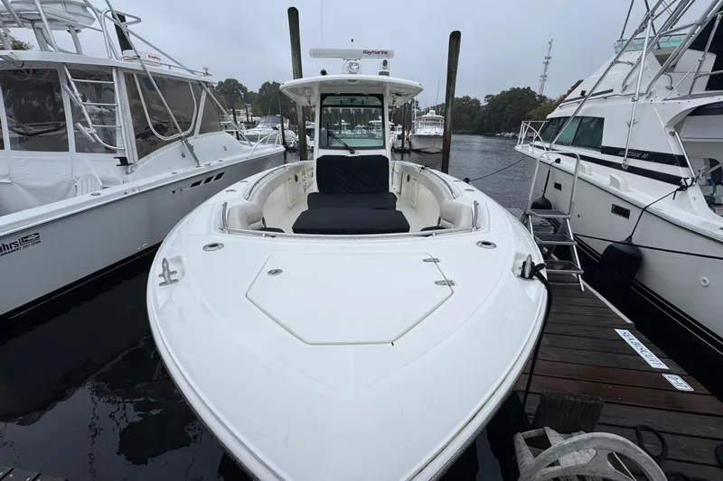  Yacht Photos Pics 2019 Boston Whaler 330 Outrage docked between boats on a cloudy day.
