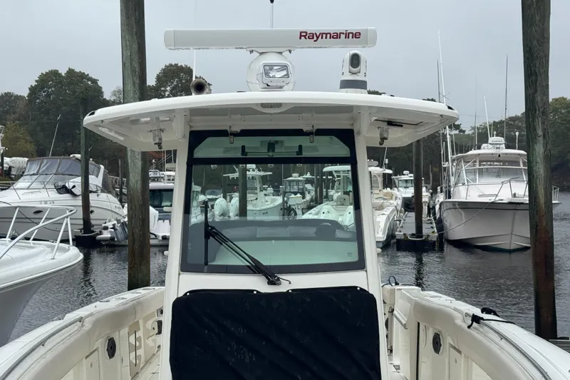  Yacht Photos Pics 2019 Boston Whaler 330 Outrage docked, featuring Raymarine equipment, surrounded by other boats.
