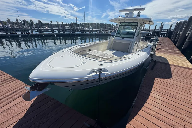  Yacht Photos Pics 2019 Boston Whaler 330 Outrage docked at a marina under a clear blue sky.