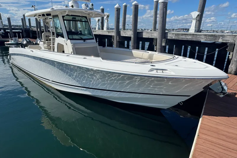  Yacht Photos Pics 2019 Boston Whaler 330 Outrage boat docked at marina under clear blue sky.