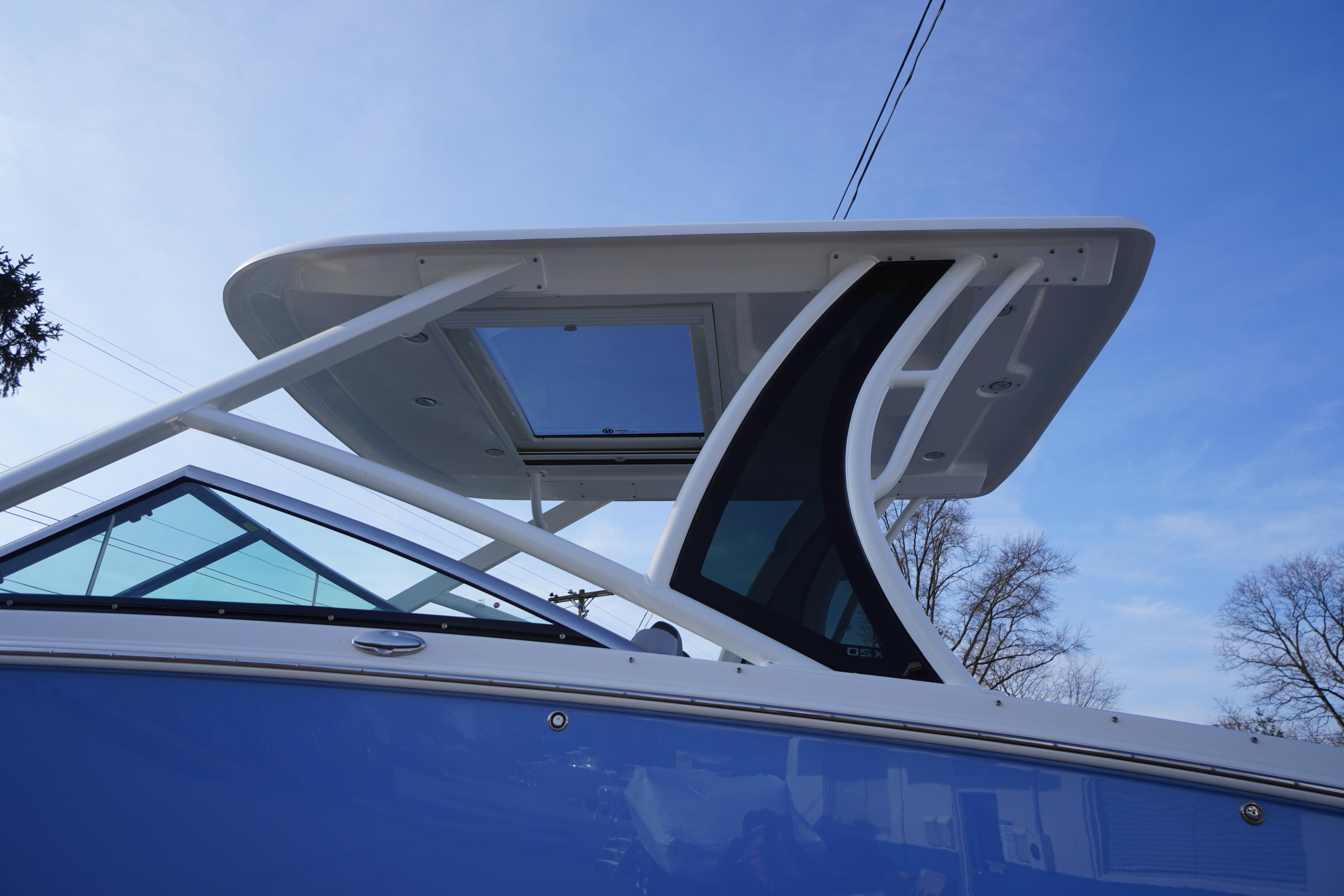 2026 Chaparral 280 OSX boat with sleek design and modern hardtop against blue sky.