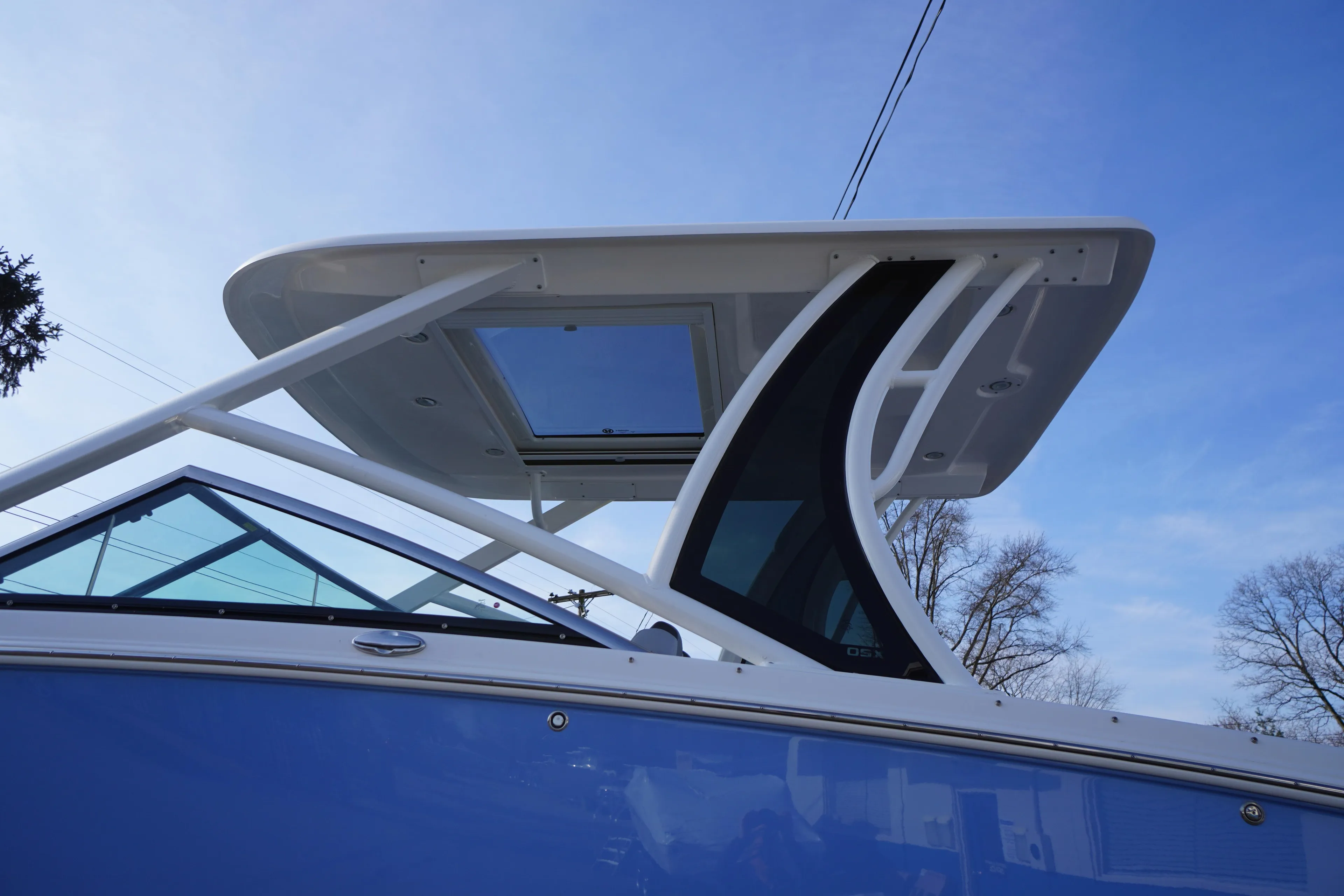 2026 Chaparral 280 OSX boat with sleek design and modern hardtop against blue sky.