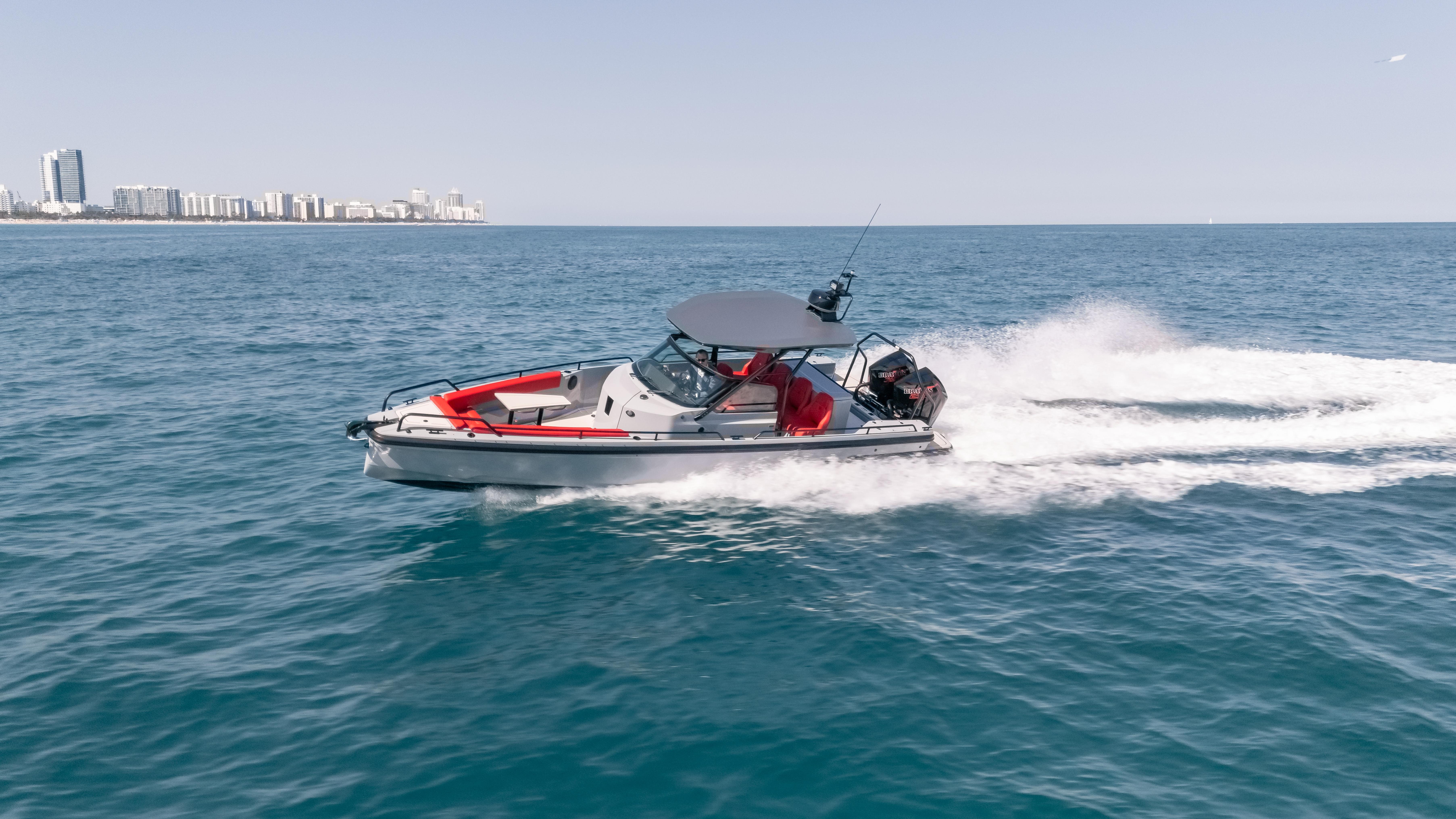 2023 BRABUS Shadow 500 T-Top cruising on open water, city skyline in background.