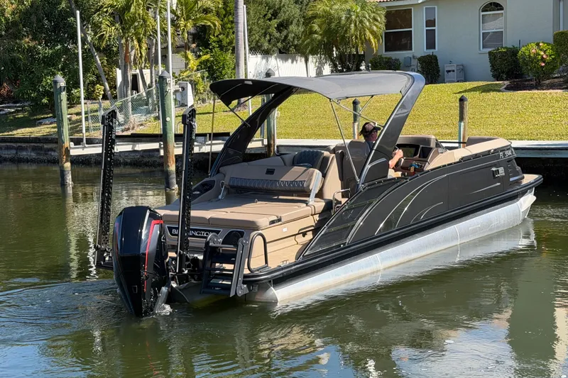  Yacht Photos Pics 2024 Bennington 25 QX Swingback pontoon boat cruising on a calm waterway.