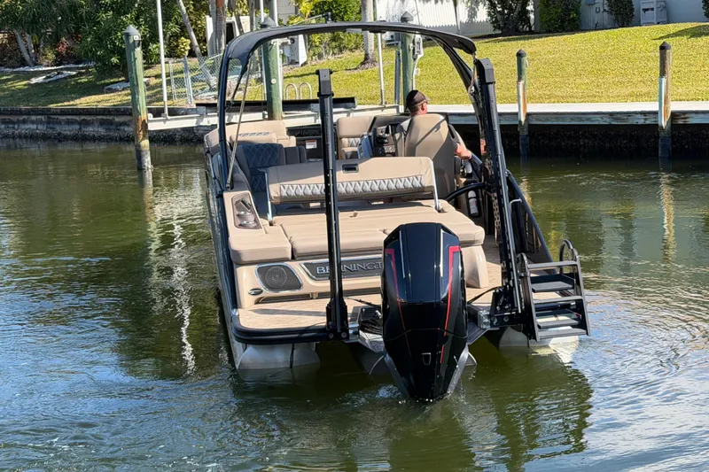  Yacht Photos Pics 2024 Bennington 25 QX Swingback boat navigating a calm waterway.