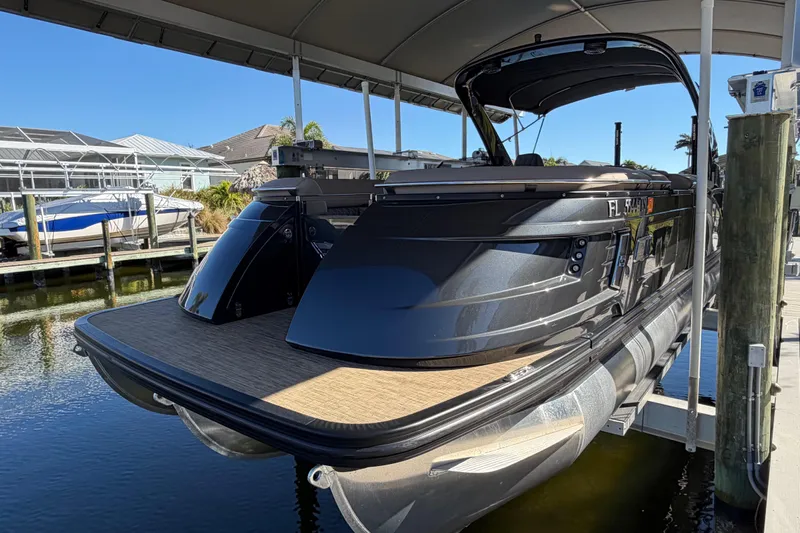  Yacht Photos Pics 2024 Bennington 25 QX Swingback pontoon boat docked under a canopy.