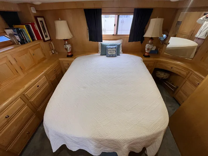 Journey Yacht Photos Pics 1999 Ocean Alexander Sundeck 460 bedroom with cozy bed, wooden cabinets, and nautical decor.