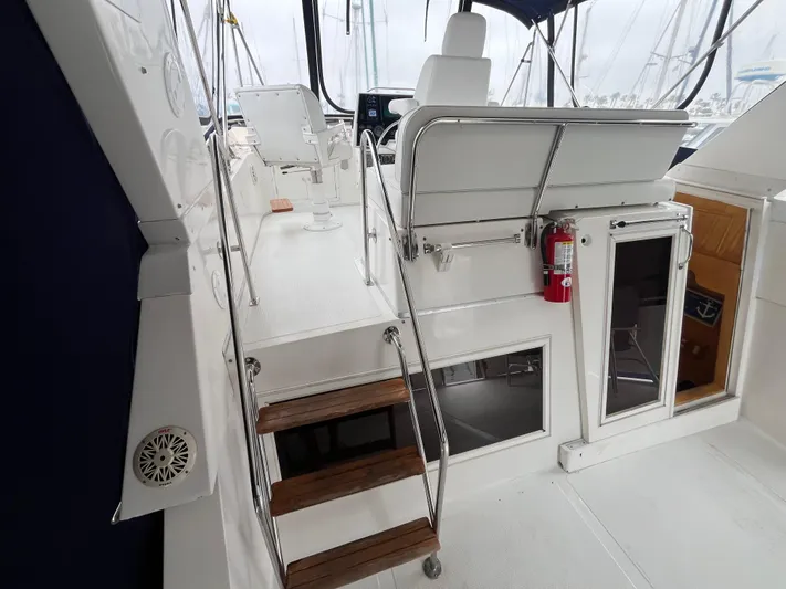 Journey Yacht Photos Pics Ocean Alexander Sundeck 460 yacht interior, featuring seating, stairs, and a fire extinguisher, 1999 model.