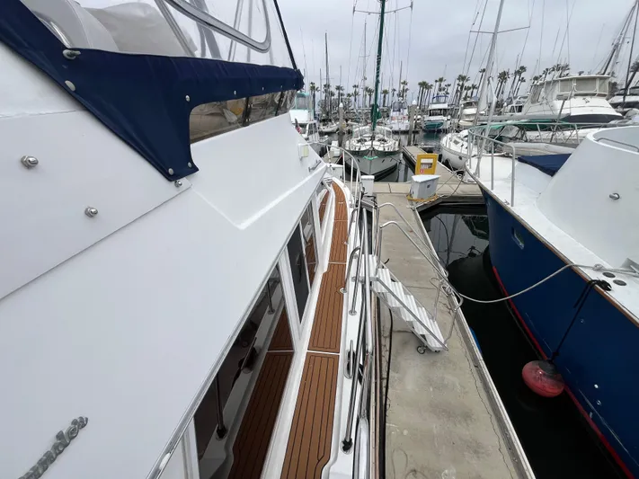 Journey Yacht Photos Pics 1999 Ocean Alexander Sundeck 460 yacht docked at marina, showcasing sleek design and wooden deck.