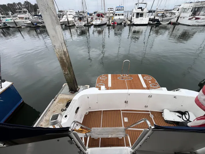 Journey Yacht Photos Pics Ocean Alexander Sundeck 460, 1999 model, docked at a marina with wooden deck and boats nearby.