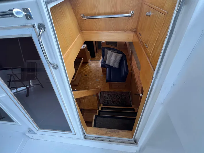 Journey Yacht Photos Pics Interior view of 1999 Ocean Alexander Sundeck 460 yacht, featuring wooden stairs and seating area.