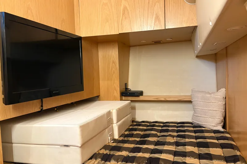  Yacht Photos Pics 1999 Tiara Yachts 4000 Express cabin with TV, bed, and wooden cabinetry.