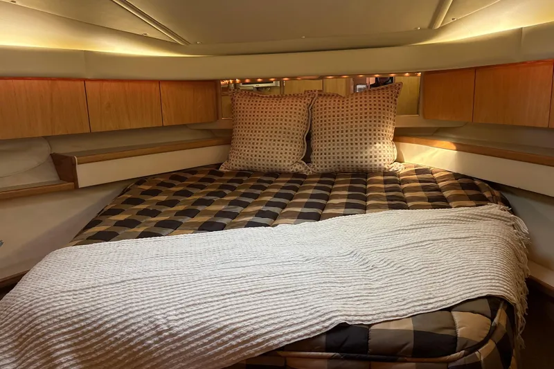  Yacht Photos Pics 1999 Tiara Yachts 4000 Express cabin with cozy bed and wooden cabinetry.