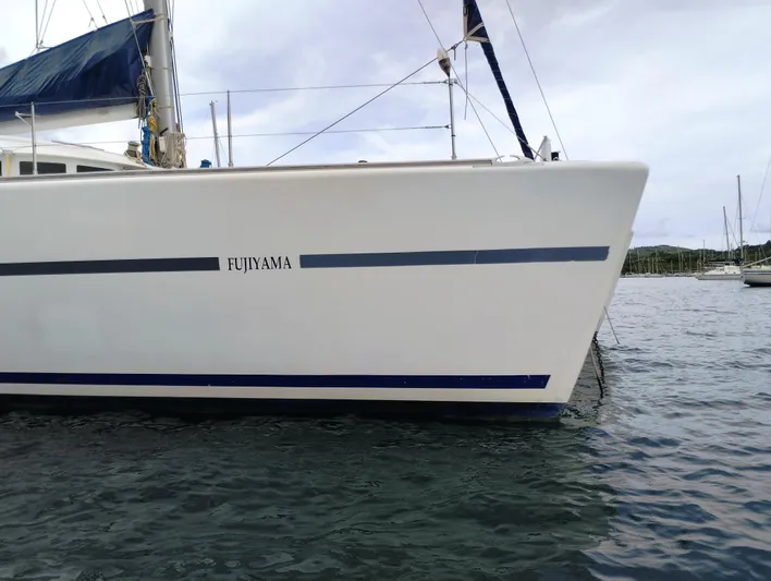  Yacht Photos Pics 2004 Lagoon 570 catamaran named Fujiyama docked in calm waters.