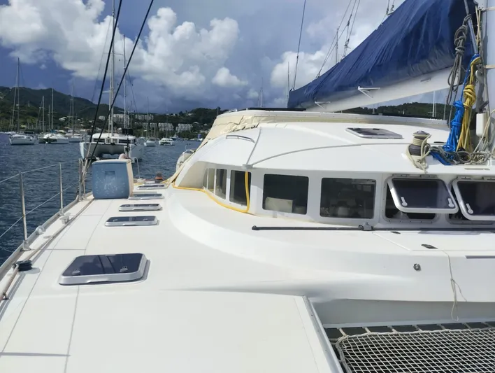  Yacht Photos Pics 2004 Lagoon 570 catamaran on calm waters, showcasing sleek design and spacious deck.