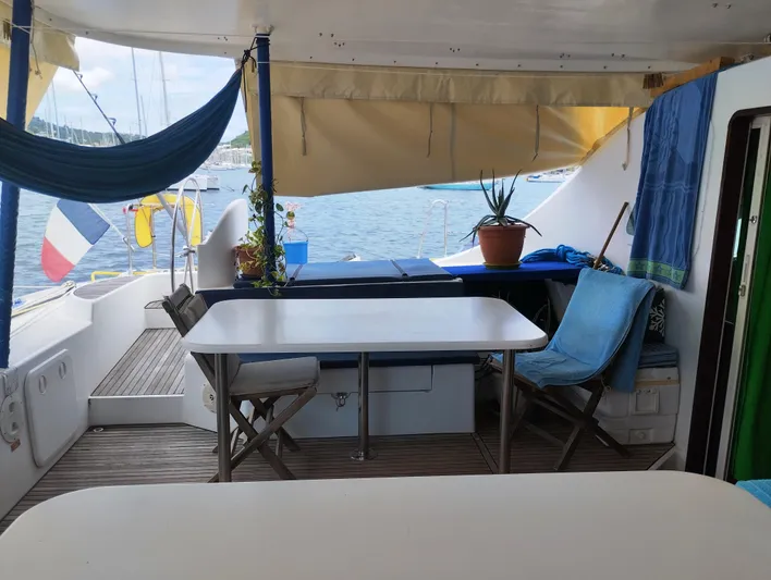  Yacht Photos Pics Lagoon 570 yacht deck with tables, chairs, and hammock, overlooking the sea.