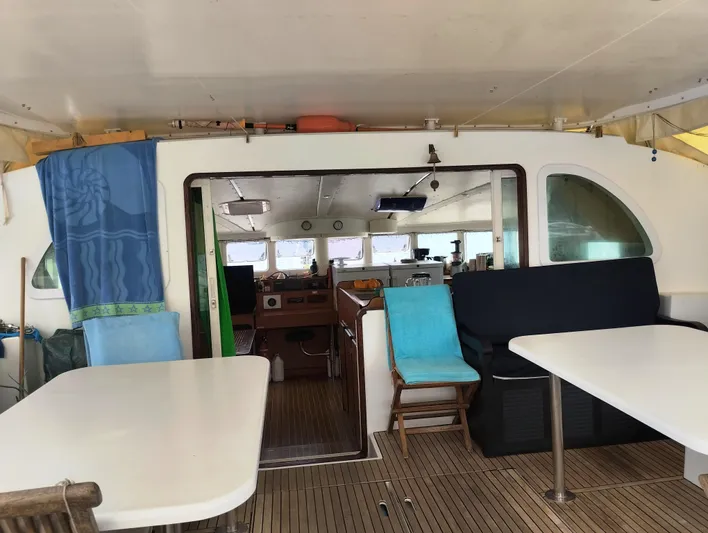  Yacht Photos Pics Interior view of a 2004 Lagoon 570 catamaran, featuring a spacious seating area and tables.