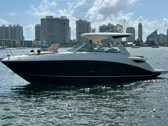 Caledonia II Yacht Photos Pics 2016 Sea Ray 350 Sundancer yacht on water with city skyline background.