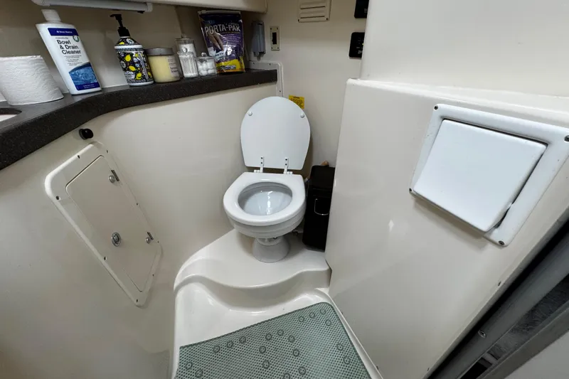 Yacht Photos Pics 2001 Grady-White Express 330 boat bathroom with toilet and cleaning supplies.