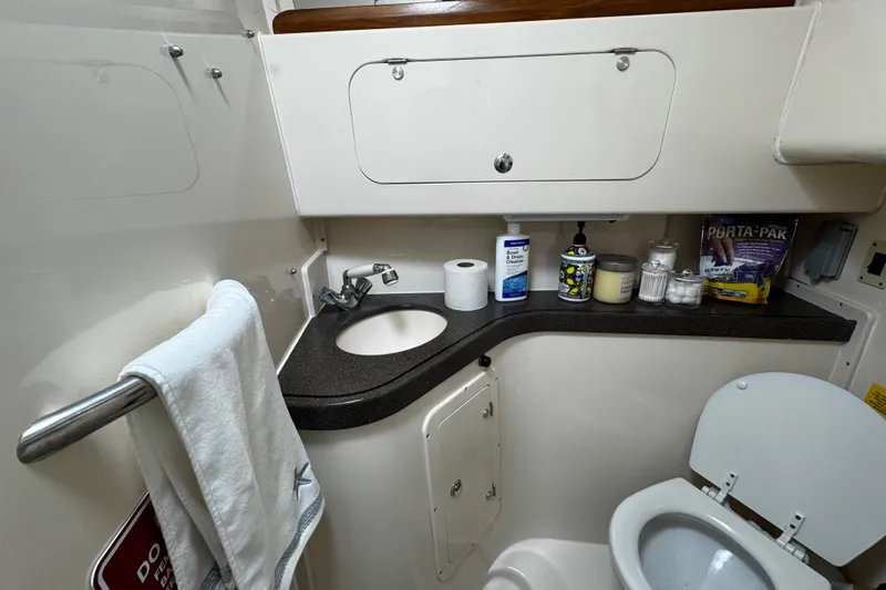  Yacht Photos Pics 2001 Grady-White Express 330 boat bathroom with sink, toilet, and storage cabinets.