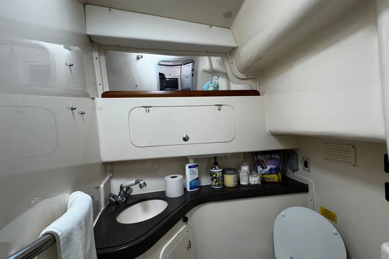  Yacht Photos Pics 2001 Grady-White Express 330 boat bathroom with sink, mirror, and storage cabinets.