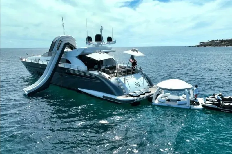  Yacht Photos Pics Luxurious 2008 Leopard 112 yacht with slide, floating lounge, and jet skis on open sea.