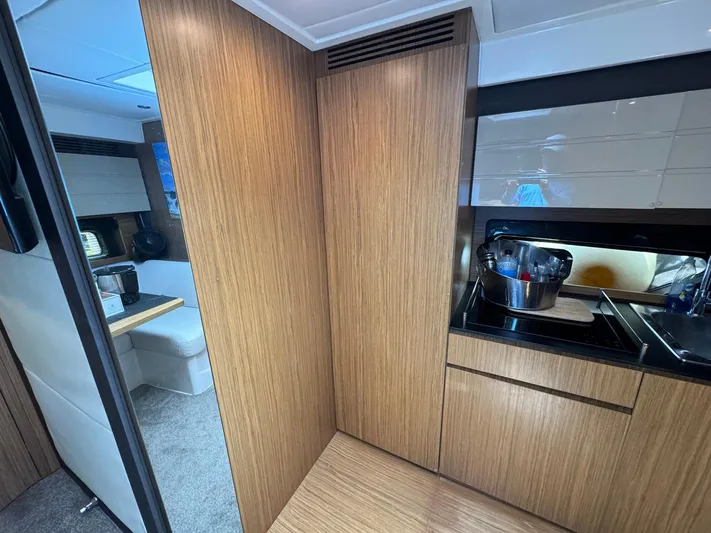 Onkor II Yacht Photos Pics Interior of 2015 Azimut Atlantis 43 yacht with modern wood cabinetry and compact kitchen area.