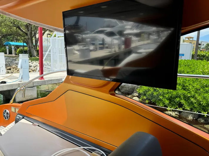 Onkor II Yacht Photos Pics Flat-screen TV on 2015 Azimut Atlantis 43 yacht, docked with lush greenery in background.