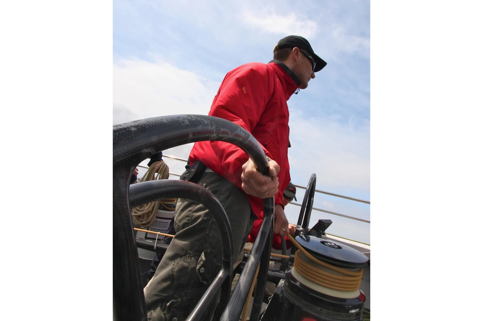 Person steering a 2002 Custom International Americas Cup Class yacht.