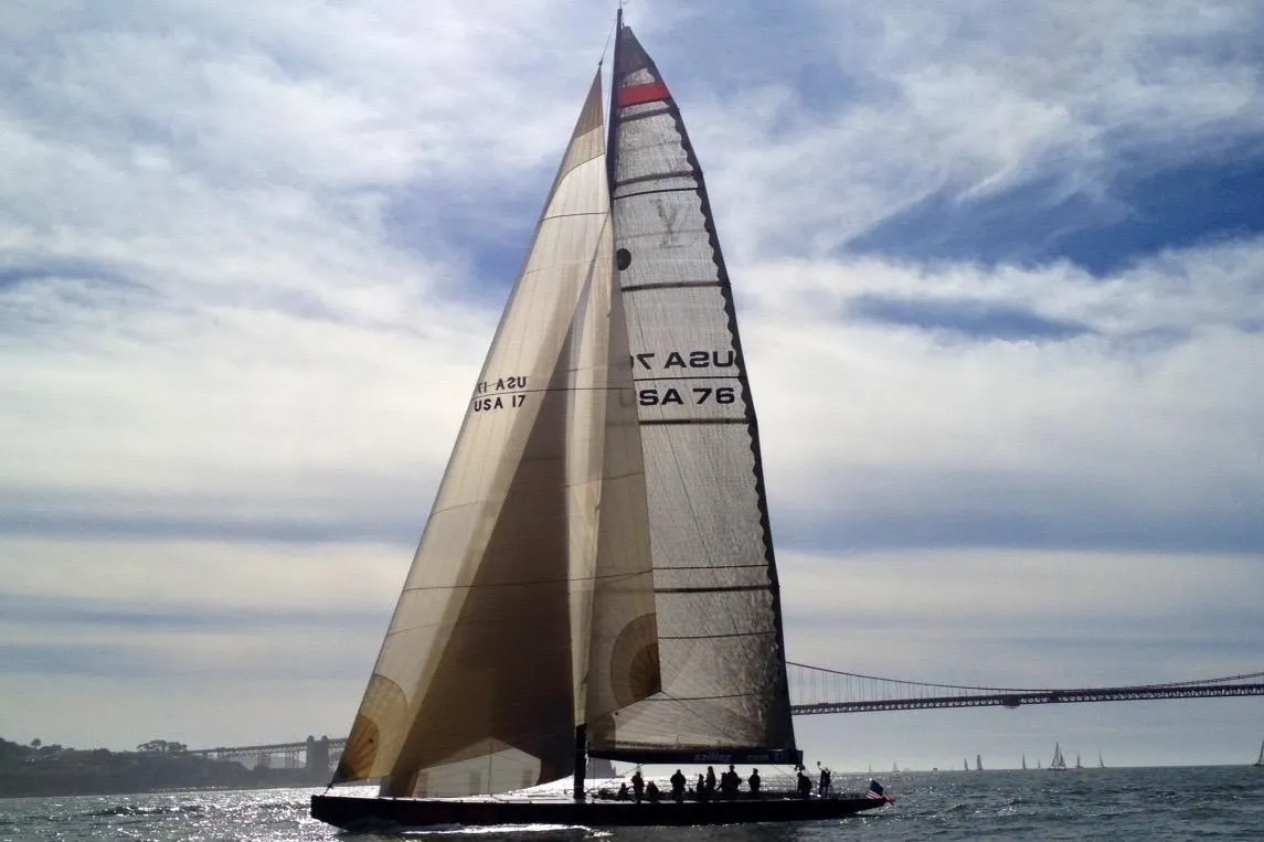 Sailing yacht on water, 2002 Custom International Americas Cup Class, under cloudy sky.