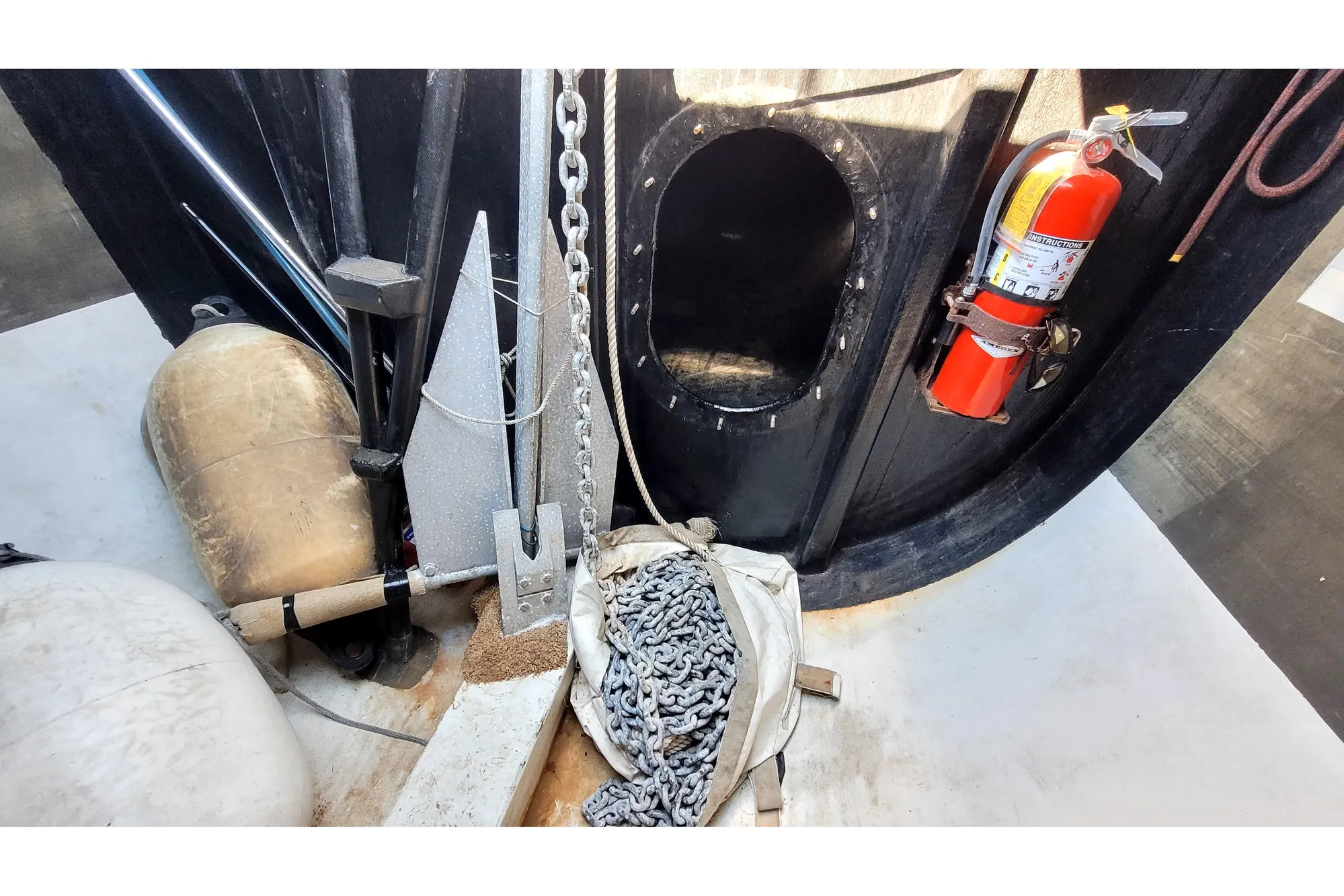 Interior of a 2002 Custom International Americas Cup Class yacht with anchor and fire extinguisher.