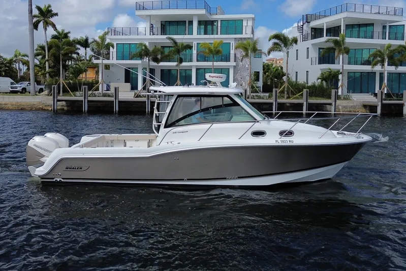  Yacht Photos Pics 2019 Boston Whaler 315 Conquest in front of modern waterfront villas.