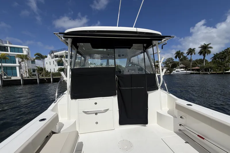 Yacht Photos Pics 2019 Boston Whaler 315 Conquest on water with modern buildings in background.
