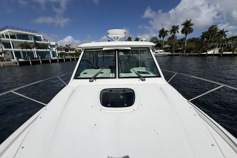  Yacht Photos Pics 2019 Boston Whaler 315 Conquest on water with palm trees in background.