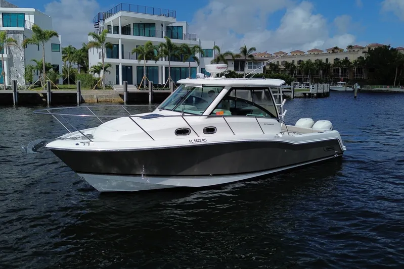  Yacht Photos Pics 2019 Boston Whaler 315 Conquest boat on water near modern homes.