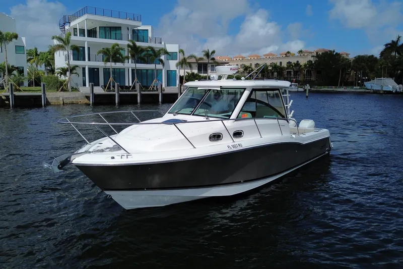  Yacht Photos Pics 2019 Boston Whaler 315 Conquest on water near modern homes.