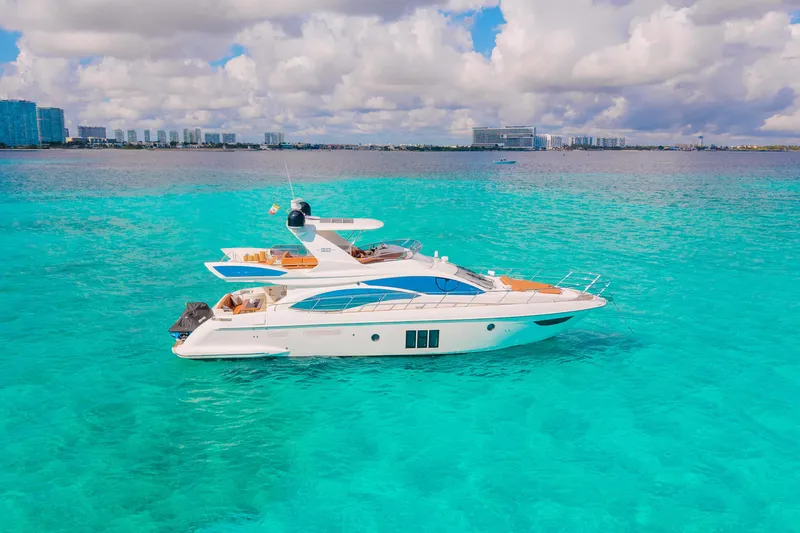 Golden Sun Yacht Photos Pics Luxurious 2011 Azimut 58 yacht on turquoise waters under a partly cloudy sky.