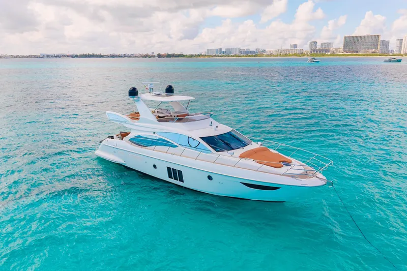 Golden Sun Yacht Photos Pics Luxurious 2011 Azimut 58 yacht on turquoise waters, city skyline in background.