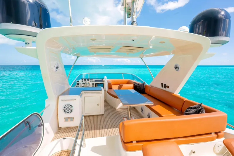 Golden Sun Yacht Photos Pics Luxurious 2011 Azimut 58 yacht with spacious deck, orange seating, and stunning turquoise ocean backdrop.
