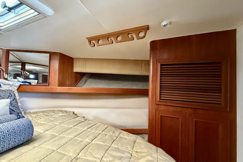 Easy Goin' Yacht Photos Pics 1996 Egg Harbor 35 Sport Fisherman cabin interior with wood accents and cozy bedding.