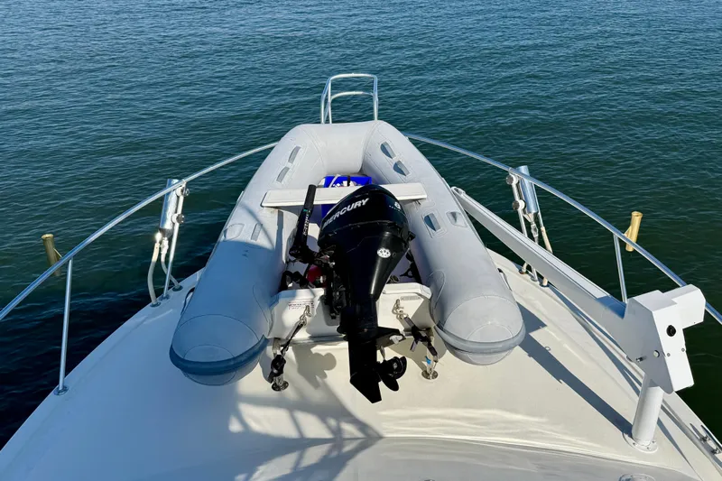Easy Goin' Yacht Photos Pics 1996 Egg Harbor 35 Sport Fisherman with inflatable boat on deck, docked on calm water.