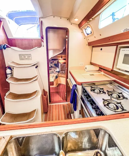 Moondust Yacht Photos Pics Interior of a 1997 Catalina 380 sailboat featuring a compact kitchen and cozy cabin.