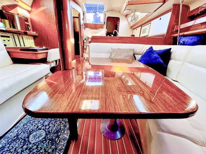 Moondust Yacht Photos Pics Luxurious interior of a 1997 Catalina 380 yacht with polished wood table and plush seating.