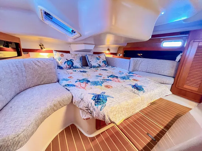 Moondust Yacht Photos Pics Cozy cabin interior of a 1997 Catalina 380 sailboat with nautical-themed bedding.