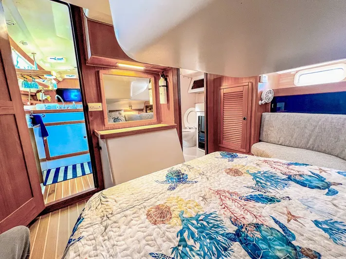 Moondust Yacht Photos Pics Cozy interior of a 1997 Catalina 380 sailboat with nautical-themed bedding.